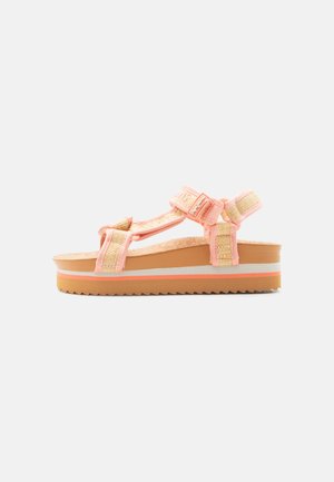 Platformsandal med fersken- og beige vævede remme og justerbare velcrolukninger på en brun sål med hvide og ferskenfarvede striber.