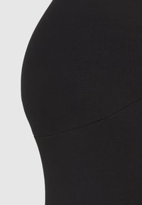 Bodysuit preto sem costuras com um tecido liso e elástico; design ajustado com uma forma curvada e costuras mínimas para um acabamento limpo.