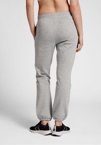 Grå bomuldsjoggerbukser med elastisk taljebånd og manchetter, med sidelommer, kombineret med sorte sportssko.