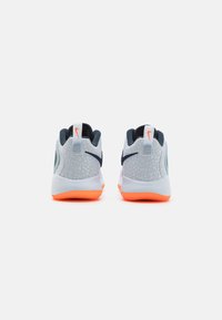 Grey athletic shoes with textured pattern on the upper, dark blue accents, an orange sole, and a padded collar for support.