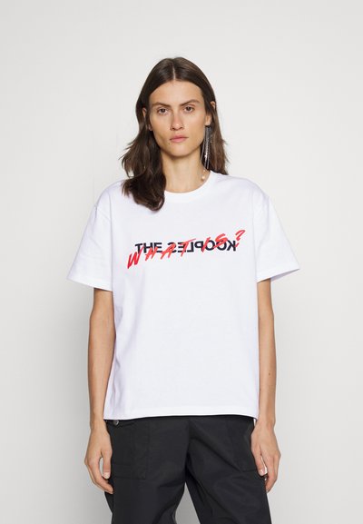 Biała bawełniana koszulka z okrągłym dekoltem, z wyraźnym, czarno-czerwonym graficznym napisem, który brzmi "THE KOOKS? CO?".
