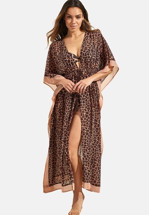 Kaftan en imprimé girafe en tissu brun transparent avec des accents beiges, présentant des côtés ouverts, un décolleté en V profond et une taille à cordon ajustable.