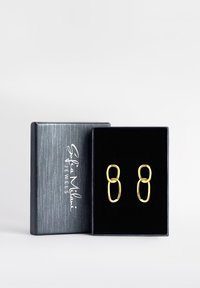 GuldFärgade örhängen med en oval länkdesign, visade i en svart sammetlåda med en silverlogotyp på locket.
