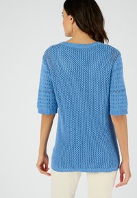 Maglione a maglia blu chiaro con un motivo morbido e struttura allentata, maniche corte e polsini a coste, con orlo dritto e tessitura aperta.