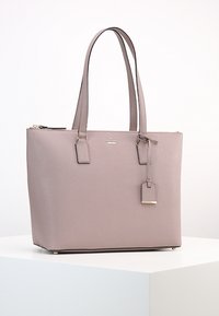 Vaaleanpunainen nahkainen käsitelaukku, jossa on kaksinkertaiset kahvat, rakenteellinen muoto, kultasävytetyt yksityiskohdat, vetoketjukiinnitys ja irrotettava nimilappu.