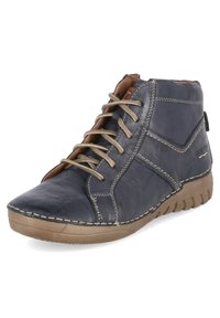 Navy leather ankle boot with beige laces, contrasting stitching, rounded toe, and rubber sole. Features a textured finish and side branding.