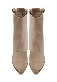Stivaletti beige in suede, con punta affusolata, texture liscia e gambale corto con un accento ad anello nella parte superiore.