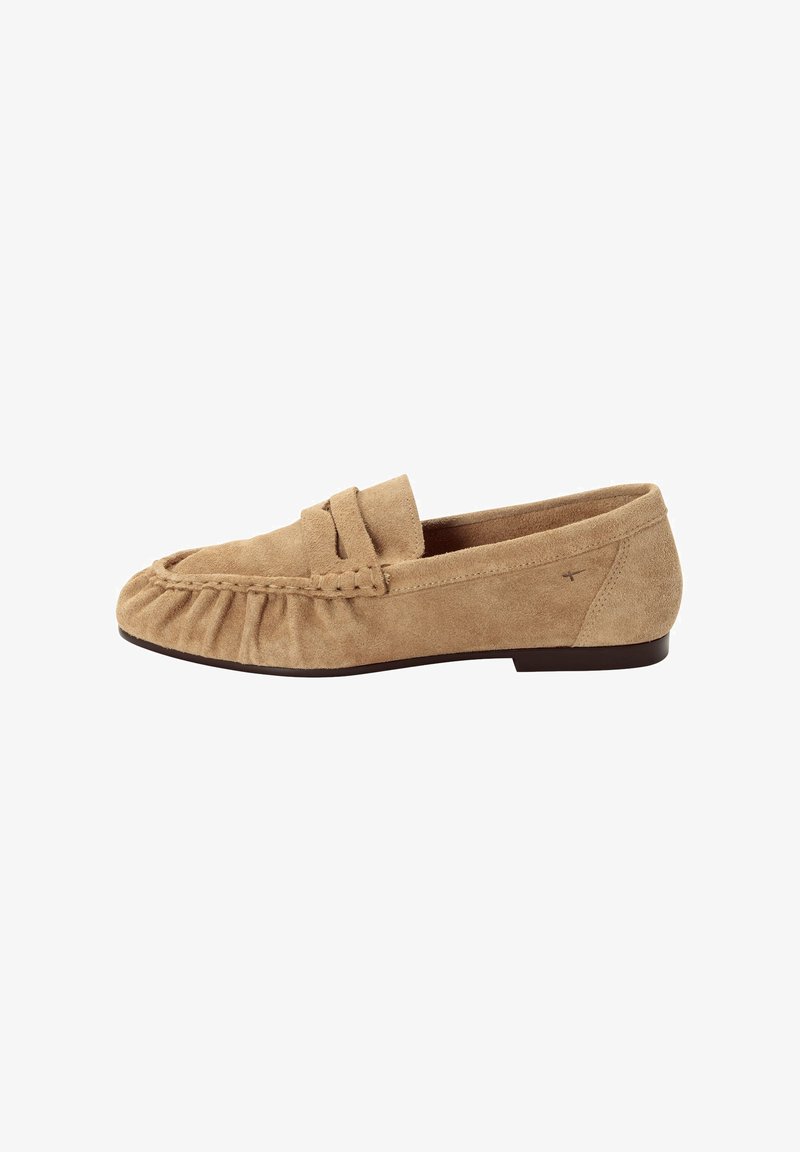 Mocassin en daim beige avec un bout froncé et une semelle plate marron foncé, présentant un détail de bride cousue sur l'empeigne.