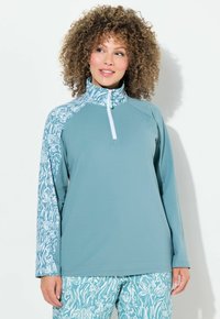 Pullover azzurro chiaro a maniche lunghe con colletto alto, dotato di una cerniera bianca e maniche decorate con disegni astratti in teal e bianco.