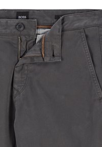 Grå BOSS-byxor med dragkedja, knappstängning och sydda detaljer, med mjuk textur och subtilt rutmönster på insidan av midjebandet.