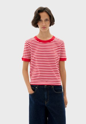 Red and white striped short-sleeve t-shirt with a ribbed neckline and cuffs, made from soft material, paired with dark blue wide-leg jeans.