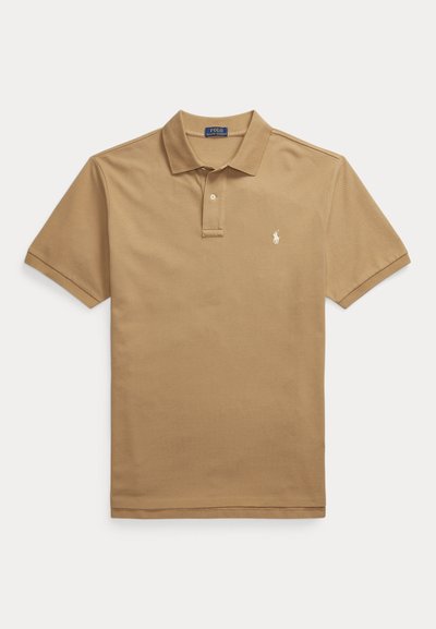 Tan polo shirt made of cotton with a classic collar, short sleeves, and a small embroidered logo on the left chest. Plain texture.