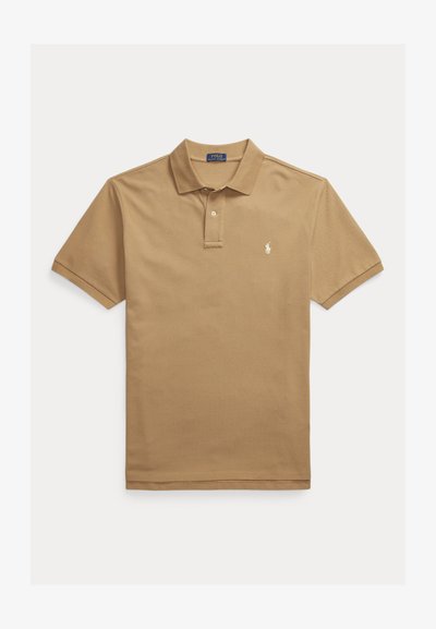 Tan polo shirt made of cotton with a classic collar, short sleeves, and a small embroidered logo on the left chest. Plain texture.