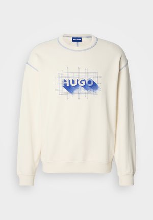 Krémová mikina s modrou grafikou "HUGO" a mriežkovým vzorom, s rebrovanými manžetami a výstrihom, a kontrastným prešitím.