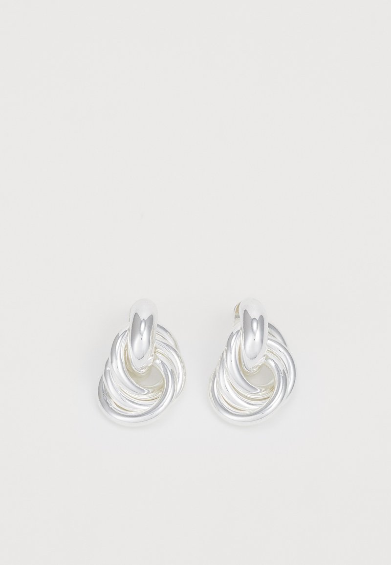 Boucles d'oreilles en argent présentant un design tordu et tourbillonnant avec une finition lisse. Des accents arrondis et polis rehaussent la forme sculpturale.