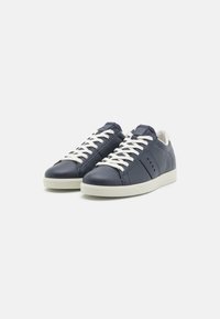 Sneakers in pelle blu con lacci bianchi e suola in gomma chiara. Presentano dettagli di cucitura e perforazioni sui lati.