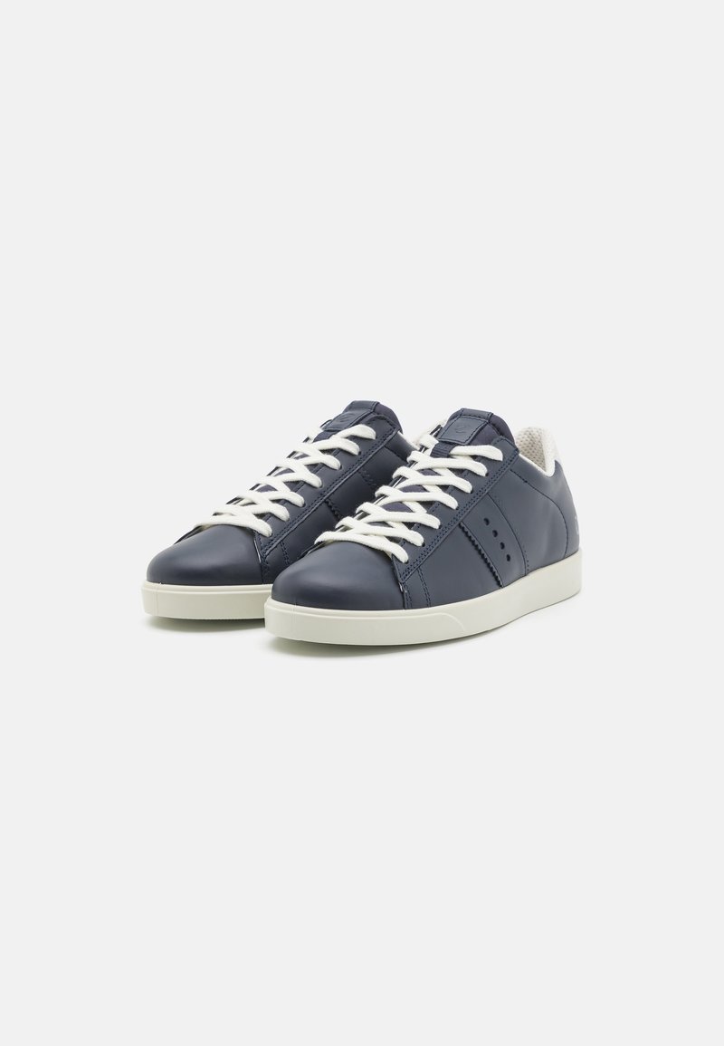 Marineblaue Leder-Sneaker mit weißen Schnürsenkeln und einer hellen Gummisohle. Verfügt über gestickte Details und Perforationen an den Seiten.