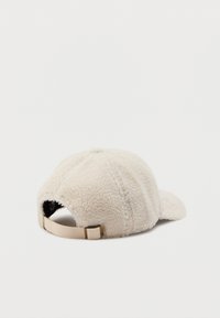Beige sherpa fleece baseballcap met verstelbare stoffen band en metalen gesp op een witte achtergrond.