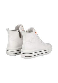 Zapatillas altas de cuero sintético blanco con una suela a rayas negras, presentan una cremallera trasera, un acento naranja y una superficie texturizada.