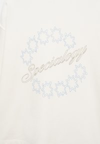 Tessuto bianco con stelle blu ricamate disposte in cerchio e la parola "Specialogy" ricamata diagonalmente al centro.