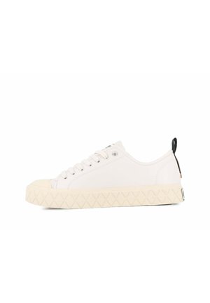 Baskets en toile blanches avec un bout rond, semelle en caoutchouc crème texturée, six œillets et un accent noir sur l'onglet du talon.