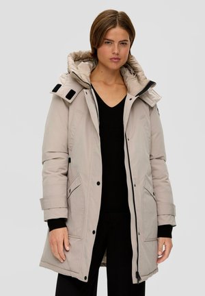 Lichtbeige ritsparka met een afneembare capuchon, twee voorzakken en zwarte accenten. Beschikt over een gevoerde binnenvoering en verstelbare manchetten.