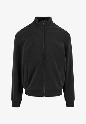 Veste en polaire noir à fermeture éclair avec col haut, manches longues et poches latérales. Présente une texture lisse et des poignets et un ourlet élastiques.