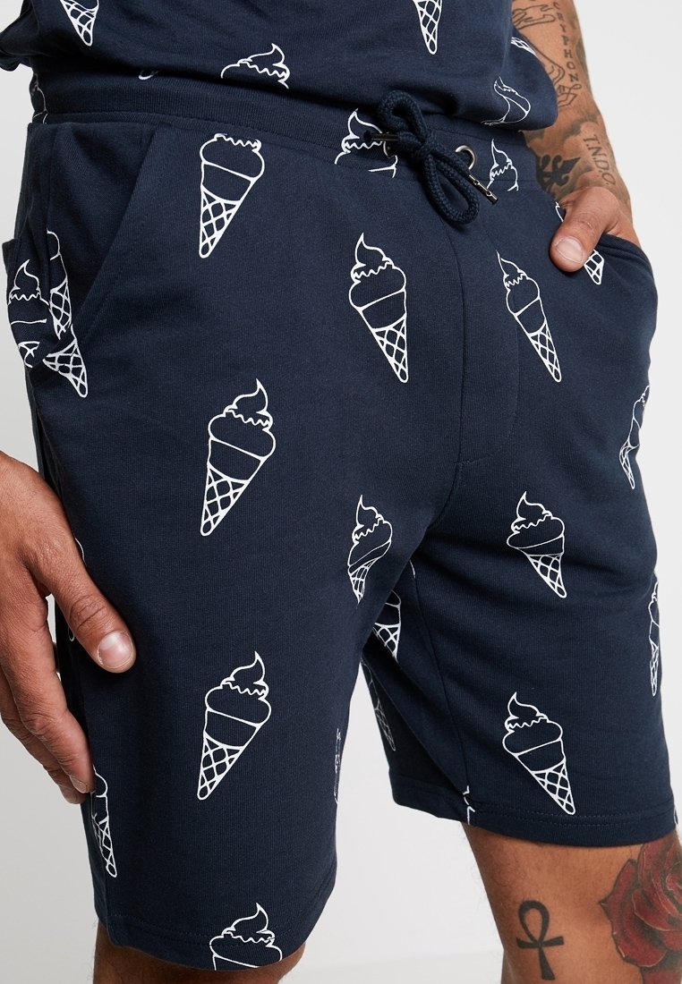 Marineblå shorts lavet af bomuld med en blød tekstur, prydet med et gentaget mønster af hvide isvafler, elastisk talje og sidelommer.