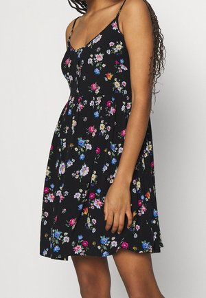 Czarna sukienka w kwiaty z dopasowaną górą, cienkimi ramiączkami i rozkloszowaną spódnicą ozdobioną kolorowymi kwiatowymi wzorami w różu, niebieskim i białym.