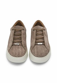 Brązowe zamszowe tenisówki o plecionej fakturze, z okrągłymi sznurowadłami i białą gumową podeszwą. Logo marki na języku, gładka wyściółka wewnętrzna.