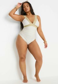 Valkoinen yksiosainen uimapuku, jossa on kultaiset koristetukkaiset hihnat, syvä V-pääntie, rypytetty sivuosa ja sopiva siluetti. Tasainen kangas.