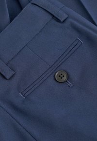 Mornarske poliesterske hlače s ravnim prednjim dijelom, jednim džepom s crnim gumbom na četiri rupe i suptilnim detaljima šivanja.