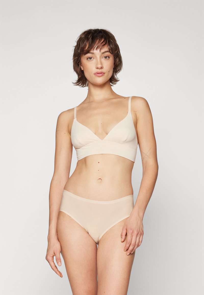 Beige bra and matching underwear, seamless design, soft fabric, v-neck style, and elastic waistband, with no visible hardware or patterns.