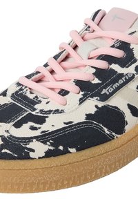 Κλείσιμο σε μαύρο-άσπρο sneaker με ροζ κορδόνια και ανοιχτό καφέ υφή σόλα, με το όνομα της μάρκας "Tamaris" στην πλευρά.