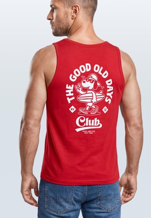 Mann trägt rotes ärmelloses Shirt mit weißem Cartoon-Hund, der ein Surfbrett hält, und dem Schriftzug „The Good Old Days Club“ auf dem Rücken.