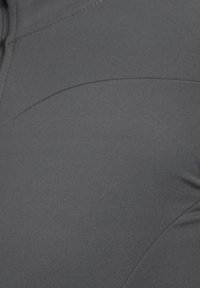 Graues sportliches Gewebe mit glatter Textur, ausgestattet mit kurvigen Nahtdetails und einem leicht taillierten Design. Keine Hardware oder Akzente sichtbar.