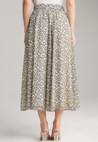 Maxi-Rock aus leichtem Stoff mit floralem Muster in Gelb, Blau und Weiß; verfügt über einen elastischen Bund und eine fließende Silhouette.