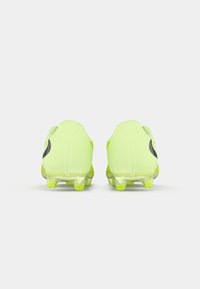 Neongule fodboldstøvler med et strømlinet design, der fremhæver en glat syntetisk overdel og en transparent sål med multidirektionale stifter.