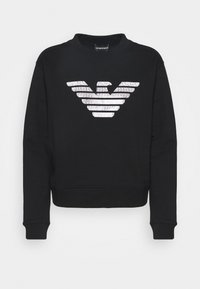 Svart sweatshirt med långa ärmar, rundad halsringning och ribbad mudd. Har en stor vit randig logotypdesign på framsidan.