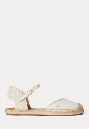 Sandale espadrille plate avec tige en toile blanc cassé, semelle en jute tressée, bout fermé et bride de cheville réglable avec boucle dorée.