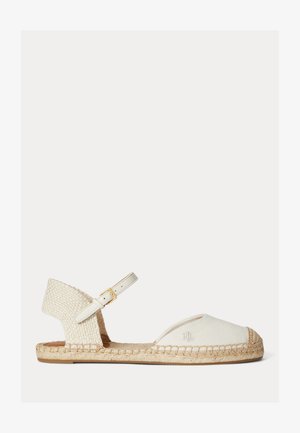 Sandale espadrille plate avec tige en toile blanc cassé, semelle en jute tressée, bout fermé et bride de cheville réglable avec boucle dorée.