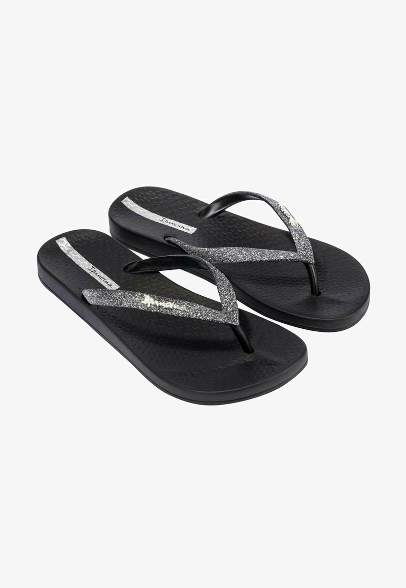 Zwarte teenslippers met een gestructureerde zool en dubbele glanzende zwarte banden. Voorzien van een zilveren accentstreep op elke band.