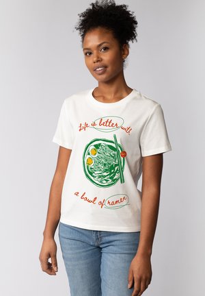 T-shirt en coton blanc avec un graphique d'un bol de ramen vert, des œufs jaunes et des baguettes. Le texte indique "La vie est meilleure avec un bol de ramen."