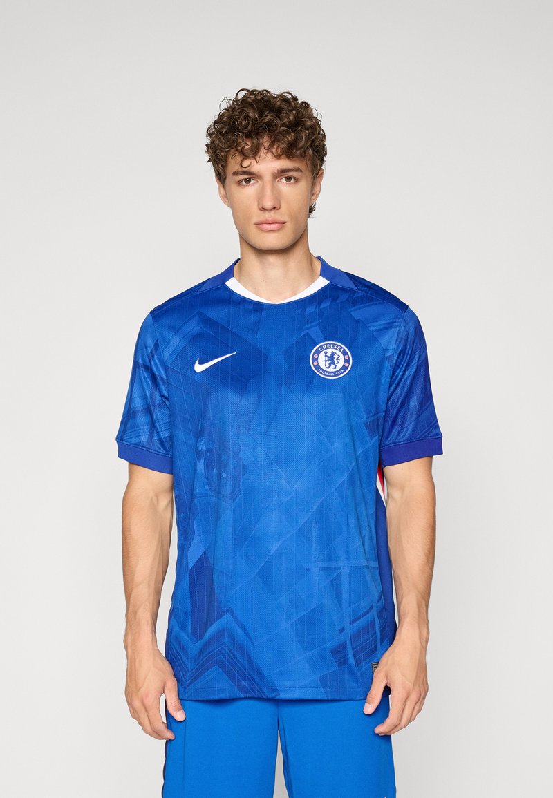 Tricou de fotbal albastru cu modele geometrice, guler rotund, mâneci scurte și un logo pe piept. Fabricat dintr-un material ușor și respirabil.