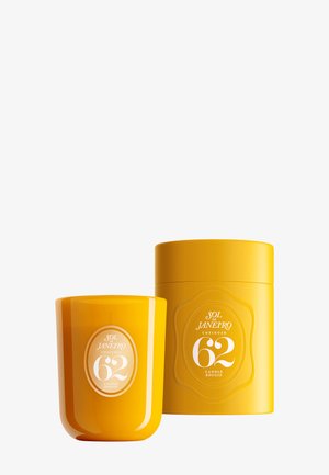 Bougie parfumée jaune vif Sol de Janeiro Cheirosa 62 avec contenant cylindrique assorti sur fond blanc.