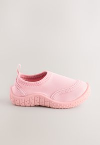 Une chaussure slip-on rose unique avec une semelle en caoutchouc texturée et une languette, conçue pour un usage décontracté ou aquatique, sur un fond neutre.