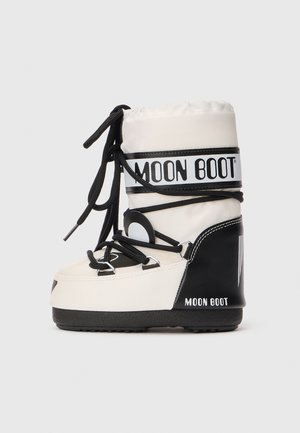 Moon Boot blanc et noir avec une semelle épaisse et des lacets noirs enroulés autour de la tige supérieure rembourrée.