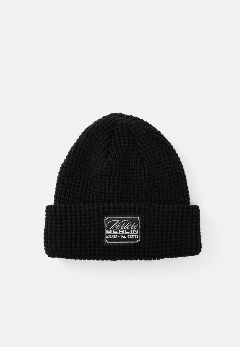 Black knitted beanie with a textured pattern and a folded cuff. Features a rectangular logo patch with "Vertere Berlin" text in white.