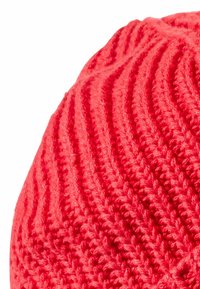 Rode gebreide beanie met ribbelstructuur, met een iets slonzig ontwerp en naadloze afwerking. Zacht garen met een gladde uitstraling.