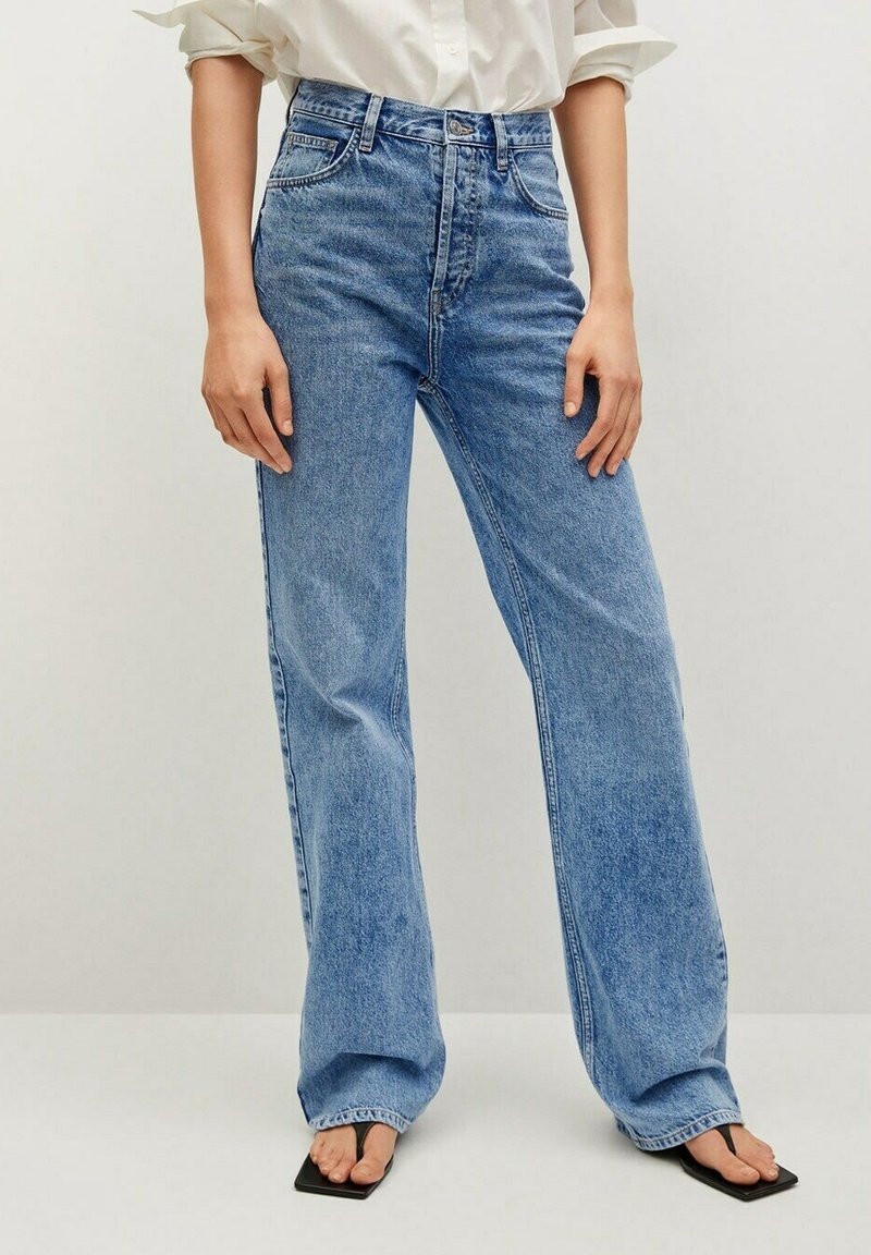 Jeans de tiro alto en azul claro con una silueta de pierna recta. Hechos de mezclilla con costuras visibles y diseño de cinco bolsillos.